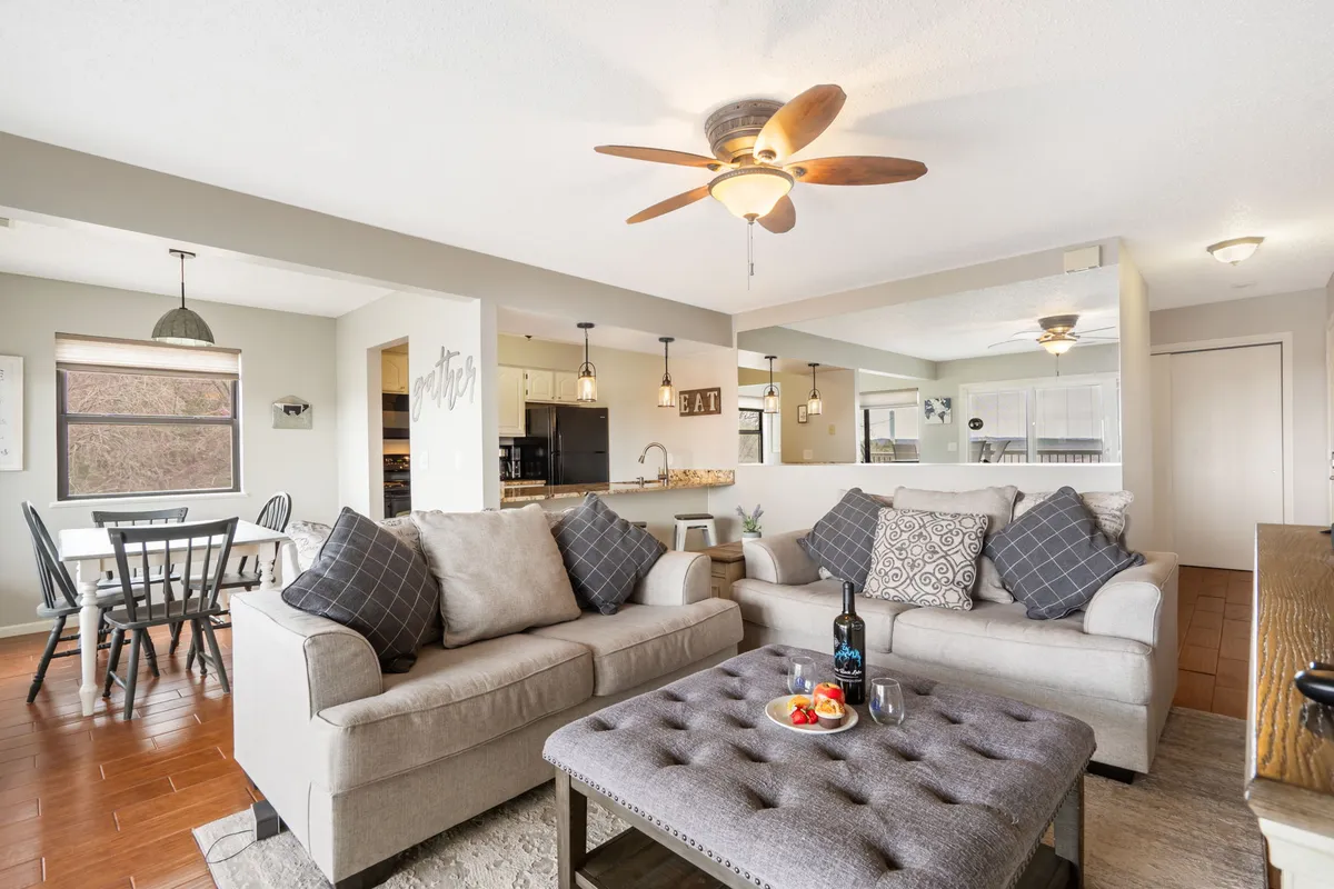 A cozy indoor living space features comfortable sofas, a coffee table, and a dining area in the background. The warm, welcoming atmosphere is suitable for families or groups to gather for board games or quiet evenings when outdoor activities wind down.