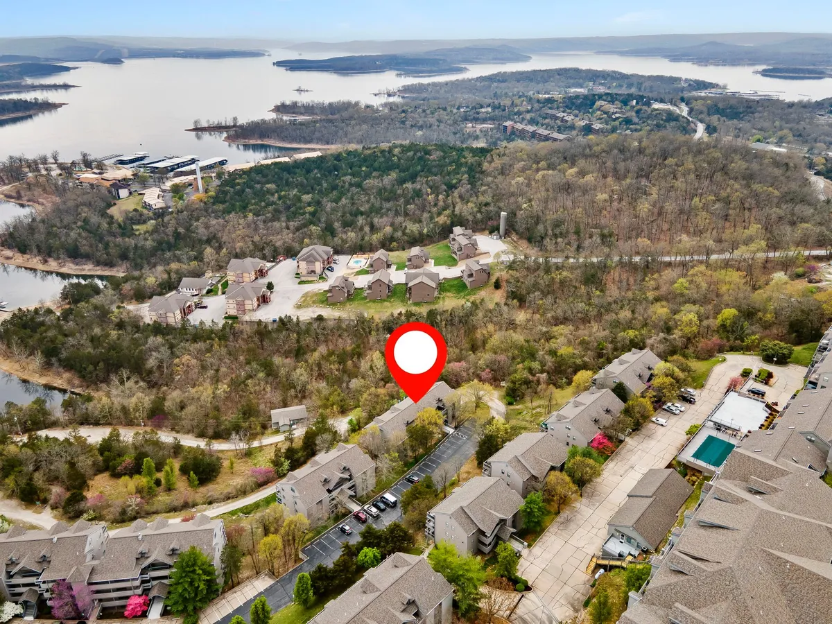 This image provides a direct, tranquil view of Table Rock Lake with residential units nestled among natural surroundings. The scene suggests a peaceful setting perfect for relaxing and enjoying sunset views, as well as access to lake activities like boating and community gatherings.